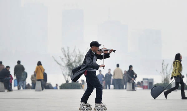 A man plays violin as he roller-skates on square on hazy day in Nanjing